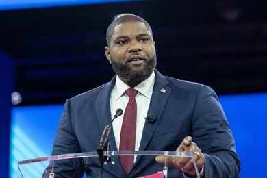 Man in a suit speaking at a podium