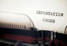 Risky Power Play: Women Sent Into Warzone? Close-up of a typewriter with a paper showing the words DEPORTATION ORDER