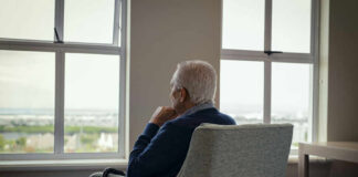 Balloon Debt Ambush In VA ‘Rescue’ Elderly man sitting in a chair, looking out a window with a thoughtful expression