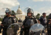 Law enforcement officers in riot gear near the Capitol building