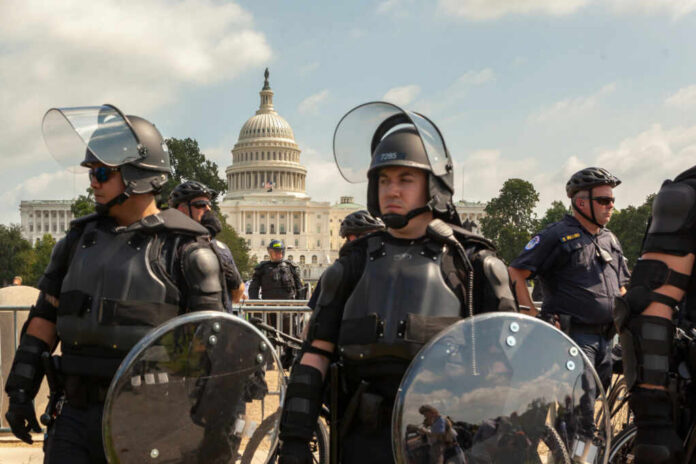 Law enforcement officers in riot gear near the Capitol building