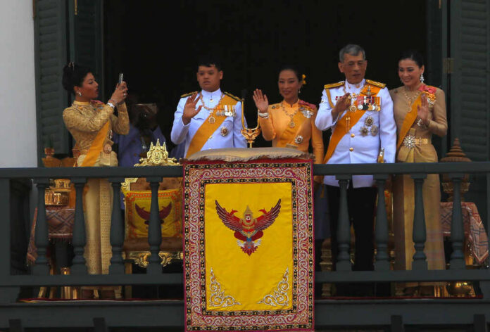 Group on palace balcony in formal attire waving