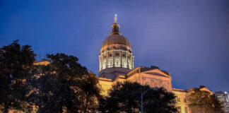 State capitol building illuminated at night with a prominent dome