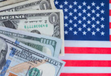 Illegal Tax Bombshell Hits Trump Plan Various denominations of US dollar bills on an American flag background