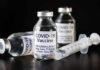 New AI Vaccine Raises Fresh Concerns Vials of COVID-19 vaccine and a syringe on a dark background