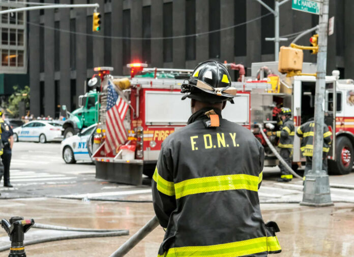 shutterstock_2289473207 Firefighter in FDNY uniform overseeing emergency response at a city intersection