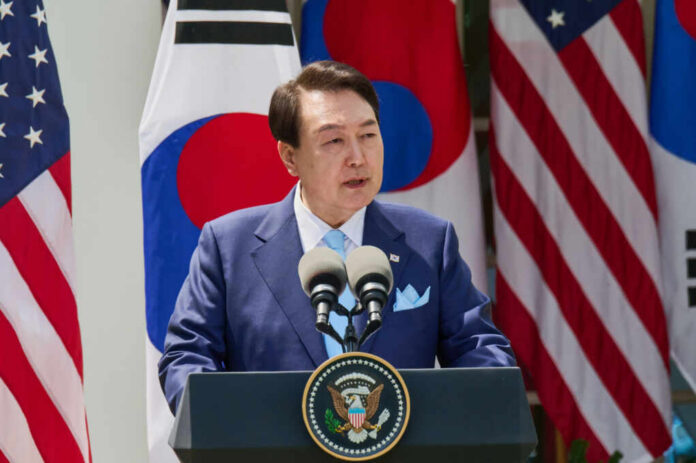 shutterstock_2303469397 A government official delivering a speech at a podium with flags in the background