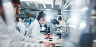 Human Brain Research Sparks Ethical Alarm Scientists working in a laboratory with microscopes and test tubes