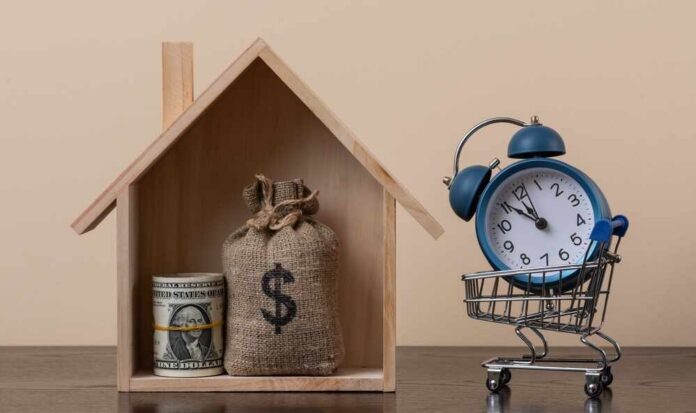 A,Symbolic,Wooden,House,,A,Stack,Of,Us$1,Bills,And A wooden house model with money and a clock in a shopping cart