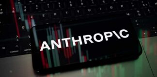 Mobile phone displaying the word 'ANTHROPIC' over a background of financial graphs