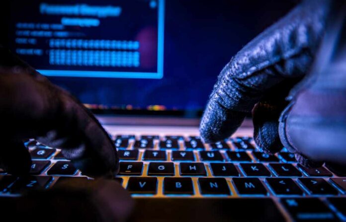 Payments,System,Hacking.,Online,Credit,Cards,Payment,Security,Concept.,Hacker Close-up of gloved hands typing on a laptop keyboard in a dark setting