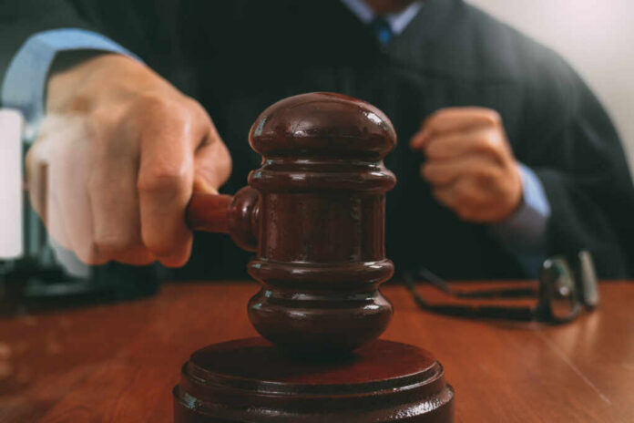 Justice,And,Law,Concept.male,Judge,In,A,Courtroom,Striking,The A judge striking a gavel on a wooden desk