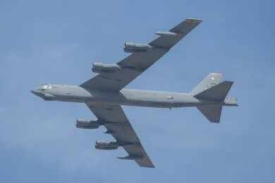 Military bomber aircraft flying against a blue sky