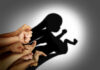Ballot Box Becomes Abortion Battleground A collection of hands creating a shadow silhouette of a fetus