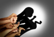 Ballot Box Becomes Abortion Battleground A collection of hands creating a shadow silhouette of a fetus