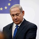 Could Israel Split The Democratic Party? man in suit at podium with EU flag in background