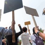 Exam Leak Sparks Nationwide Student Outrage Group of people holding protest signs outdoors