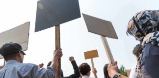 Exam Leak Sparks Nationwide Student Outrage Group of people holding protest signs outdoors