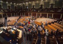 Legislative chamber with members gathering on the floor