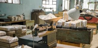 industrial scale with white powder in a cluttered warehouse