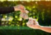 NYC Publishes ‘Hit List’ of the Rich Hands exchanging small burlap money bags outdoors