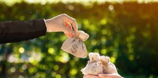 NYC Publishes ‘Hit List’ of the Rich Hands exchanging small burlap money bags outdoors