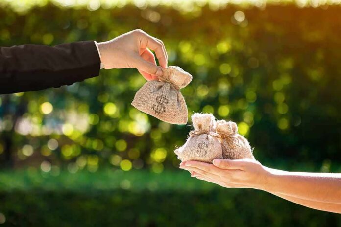 Hands exchanging small burlap money bags outdoors