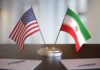 Iran Deal Unlocks Oil And Billions United States and Iran desk flags on a stand