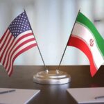 Iran Deal Unlocks Oil And Billions United States and Iran desk flags on a stand