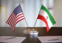 Iran Deal Unlocks Oil And Billions United States and Iran desk flags on a stand