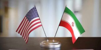 Iran Deal Unlocks Oil And Billions United States and Iran desk flags on a stand