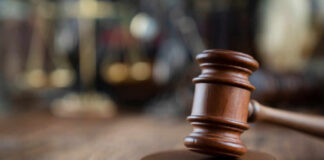 Robinson Hearing Reveals New Evidence Close-up of a wooden gavel on a wooden surface with blurred scales of justice in the background