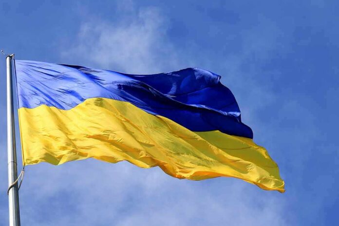 Ukrainian flag waving on a flagpole against blue sky