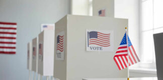 Hidden Tape Blows Up Senate Race Voting booths with American flags in a polling station