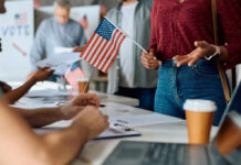 Will Senate Block SAVE America? People participating in a voting event with American flags and paperwork