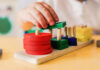 Childs hand stacking colorful wooden blocks