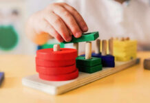 Deadly Baby Items Flood Major Marketplaces Childs hand stacking colorful wooden blocks