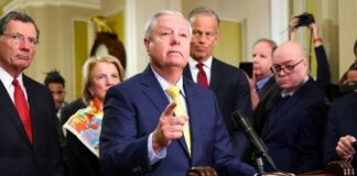 Lindsey Graham Dies Suddenly At 71 A group of government officials at a press conference with one speaking into a microphone