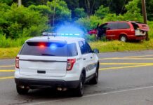 Police SUV with flashing lights at roadside crash scene