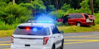 Police SUV with flashing lights at roadside crash scene
