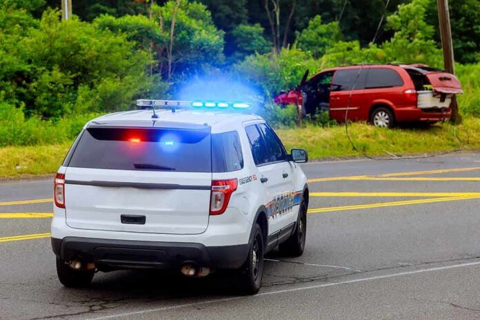 Police SUV with flashing lights at roadside crash scene