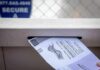 Late Votes On The Chopping Block Mail-in ballot being inserted into a secure drop box slot