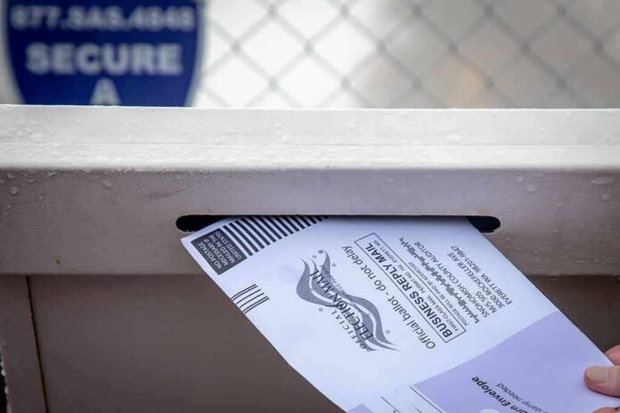shutterstock_1229925952 Mail-in ballot being inserted into a secure drop box slot
