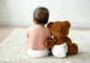 Toddler Found Alone On Balcony Baby in diaper sitting with teddy bear