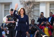 Inside Kamala Harris’s $8 Million Mansion woman in navy suit waving at outdoor event