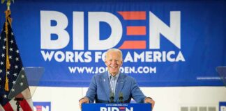 smiling man at podium during campaign event