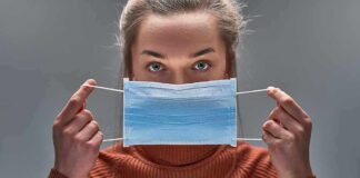 A Major Medical Study Just Got Retracted Person holding a blue surgical mask in front of their face