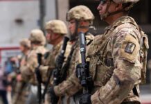 D.C. Crime Drops As Crackdown Enters Year Two Soldiers in camouflage gear stand in formation holding rifles