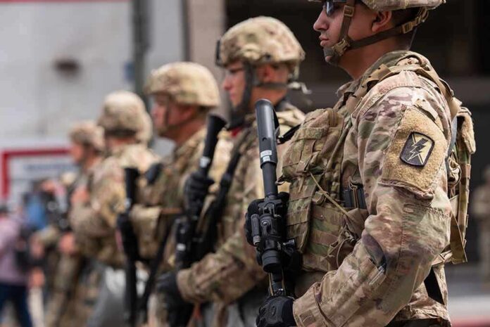 shutterstock_1748150951 Soldiers in camouflage gear stand in formation holding rifles