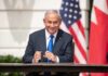 Israel Builds Strategic Alliance Network Man in suit seated at a signing table